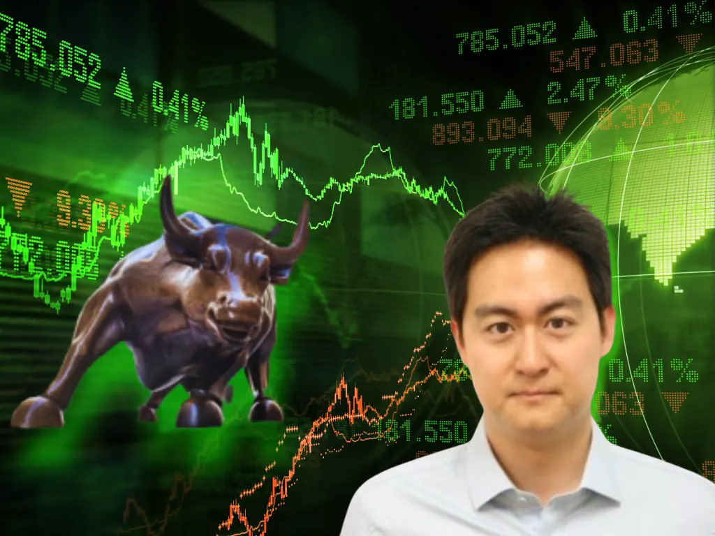 Drew Huh in standing in front of a stock chart with a bull on it